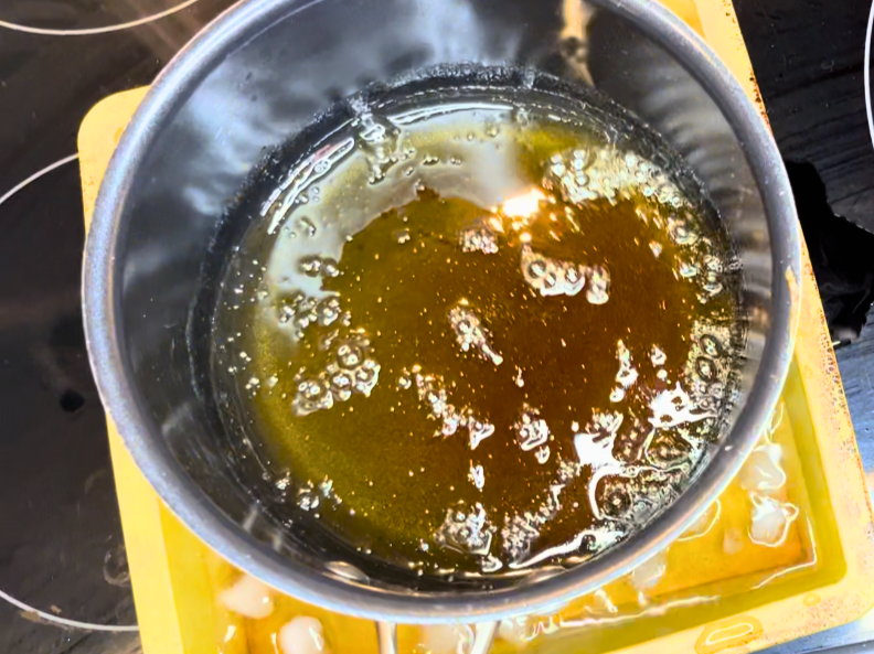 A pot of cooked caramel in an ice bath.