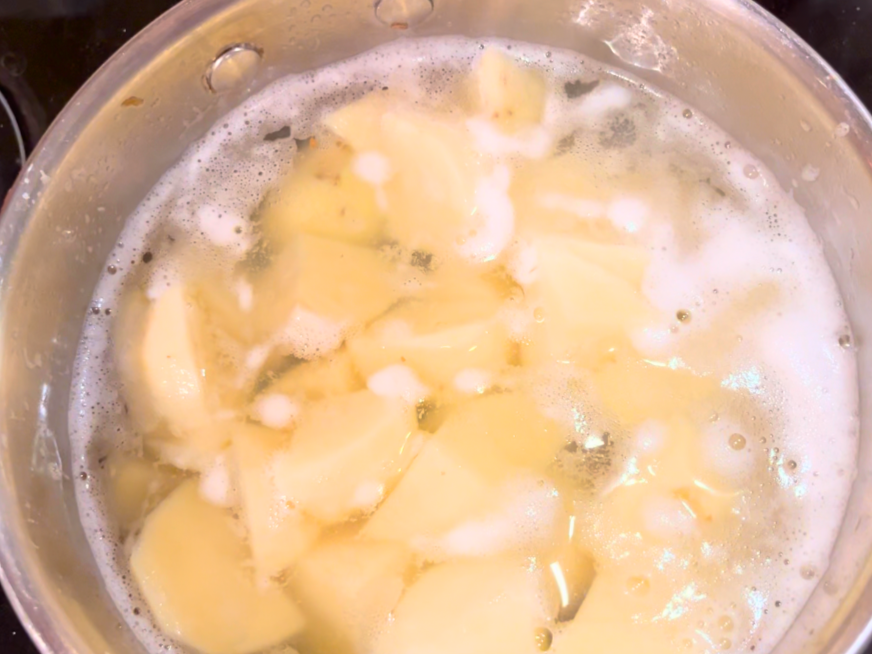 Potatoes being boiled in a stock pot.