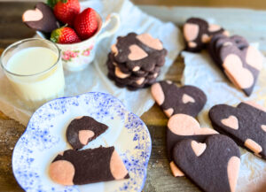 Heart cookies made with chocolate dough with pink hearts made of dough inserted through out.