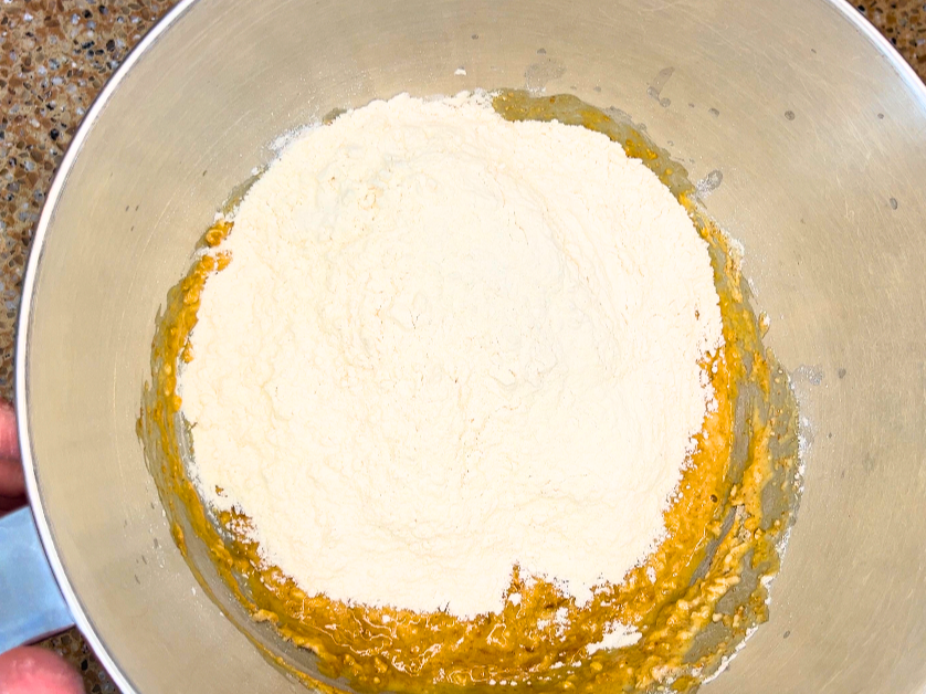 all purpose flour on top of a whole wheat flour mixture, in a large metal bowl.
