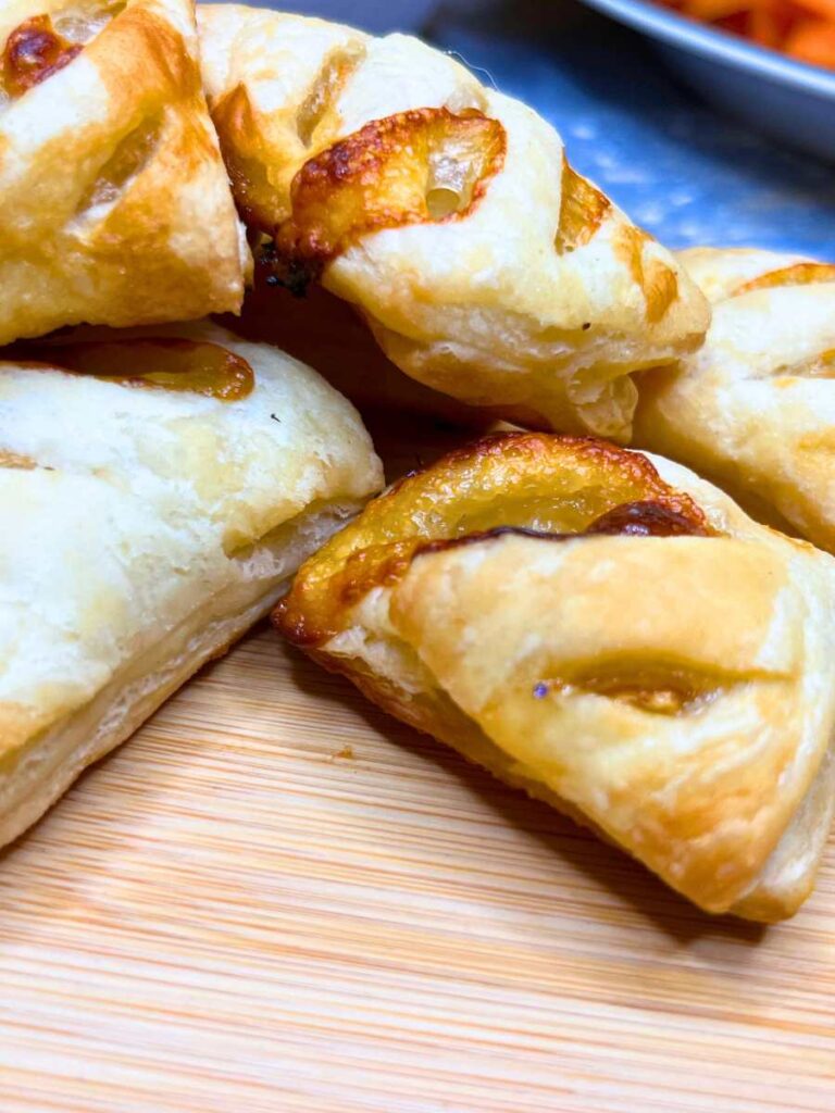 A close up look at puff pastry appetizers filled with Brie and honey.