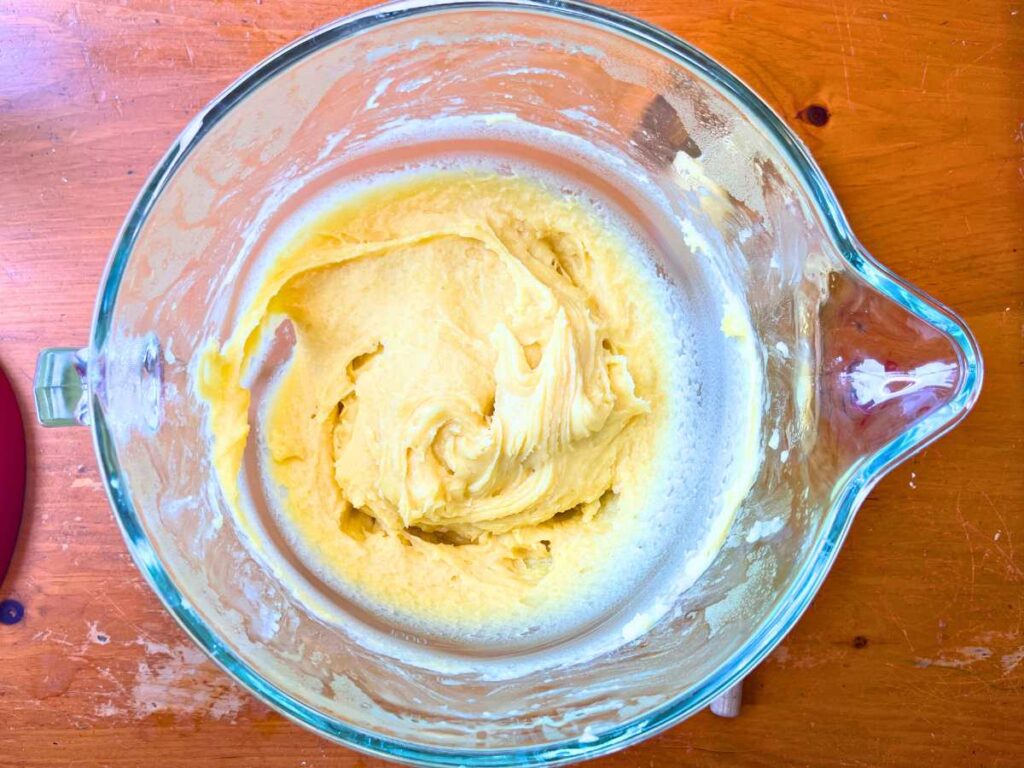 A glass bowl full of choux pastry dough.