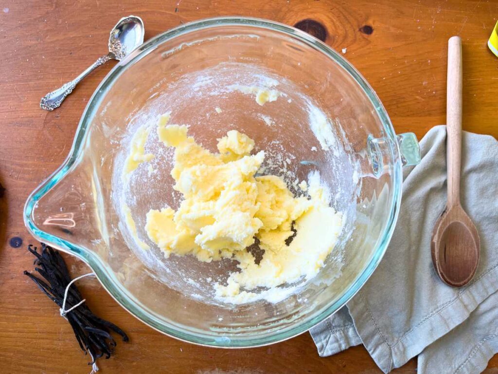 A glass bowl with creamed butter and sugar inside.