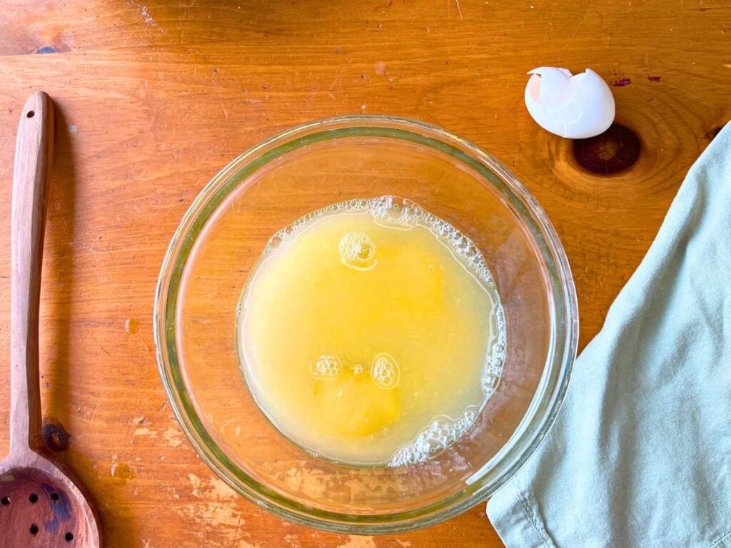 A glass bowl full of water and eggs.