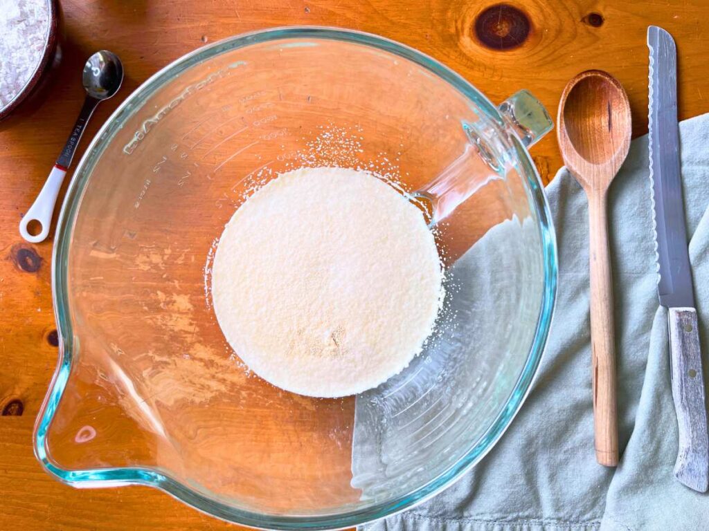 A large glass bowl with water and yeast inside.