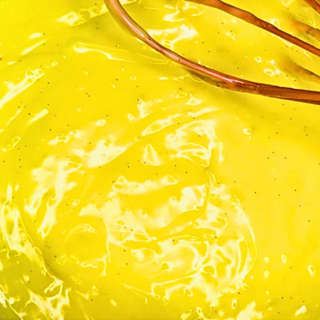 A woman is whisking vanilla pastry cream.