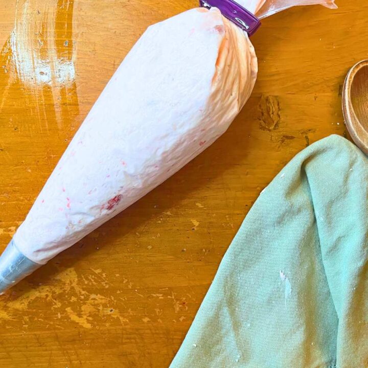 A piping bag with strawberry icing inside.