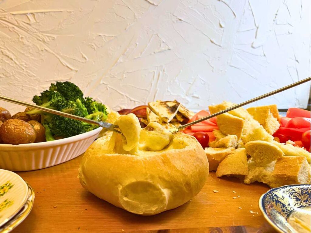 Two people dipping into a cheese fondue.