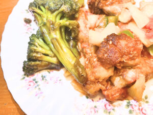 A white floral plate with Chinese food and broccoli on it.