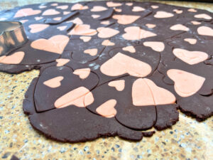 Two tone chocolate and pink cookie dough with large heart cut outs in it.