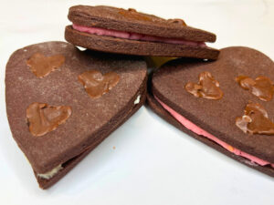 Three heart sandwich chocolate sugar cookies with chocolate hearts inside.