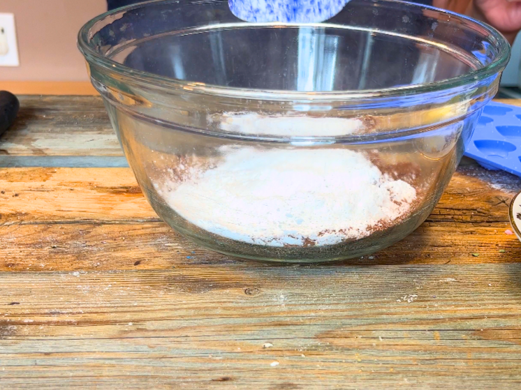 A class bowl with icing sugar inside.