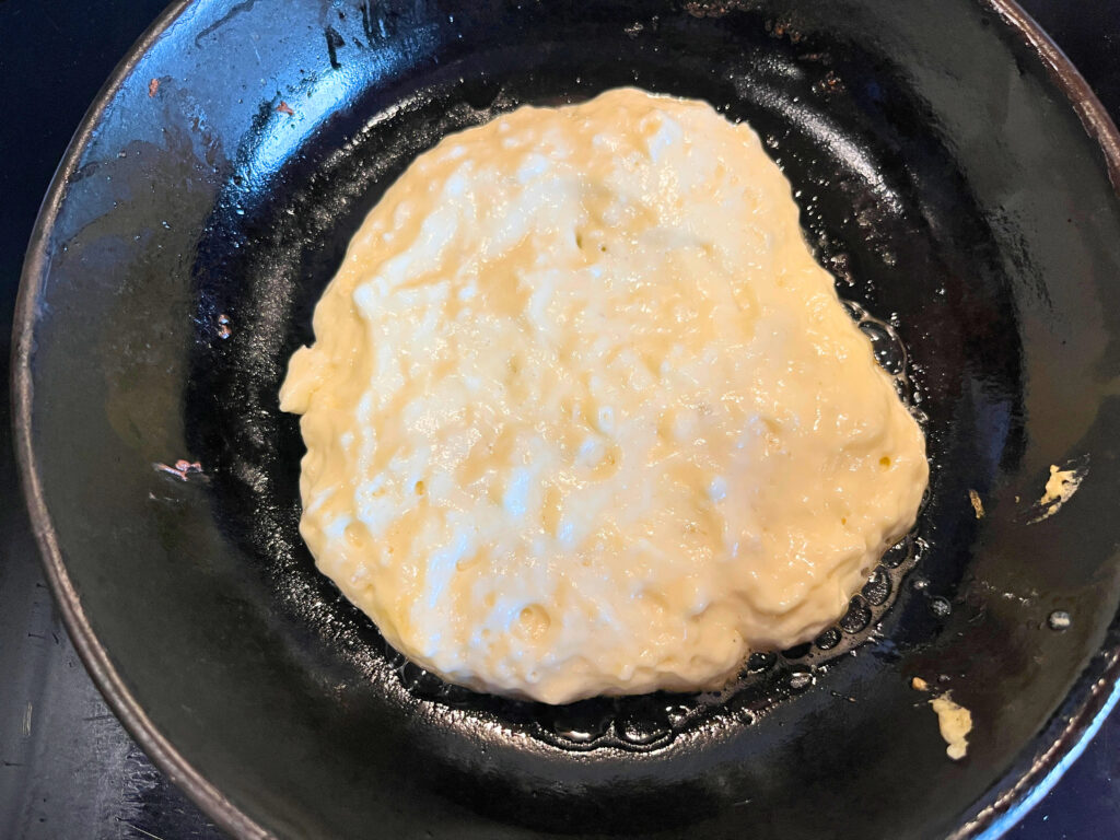A frying pan with pancake batter in it.
