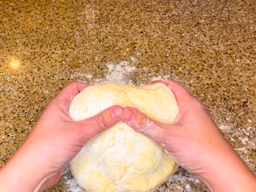 Woman holding dough.
