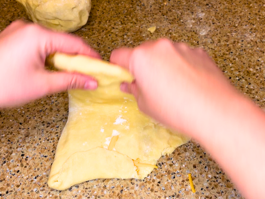 Woman folding dough.