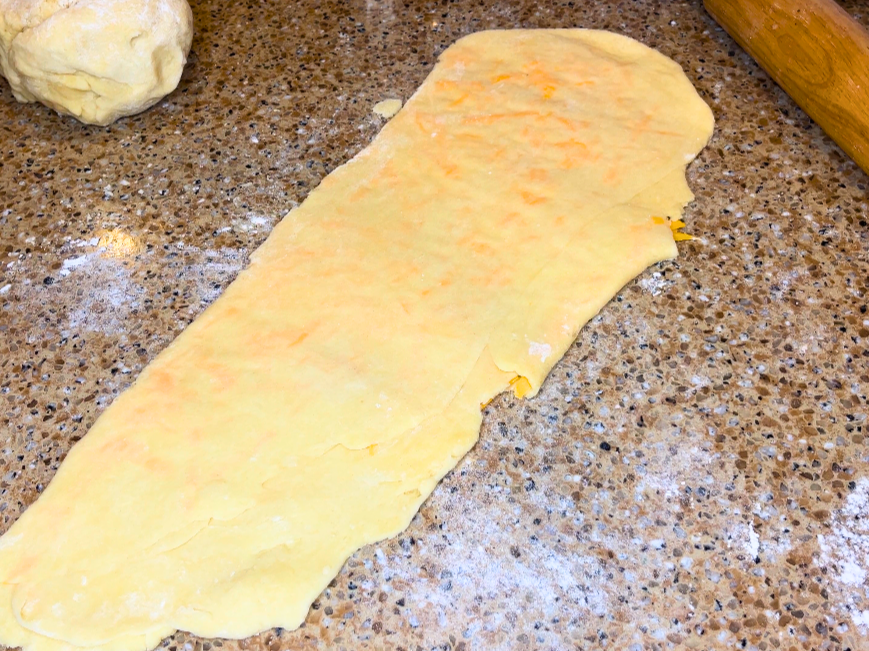 A long rolled out piece of dough with cheese inside.