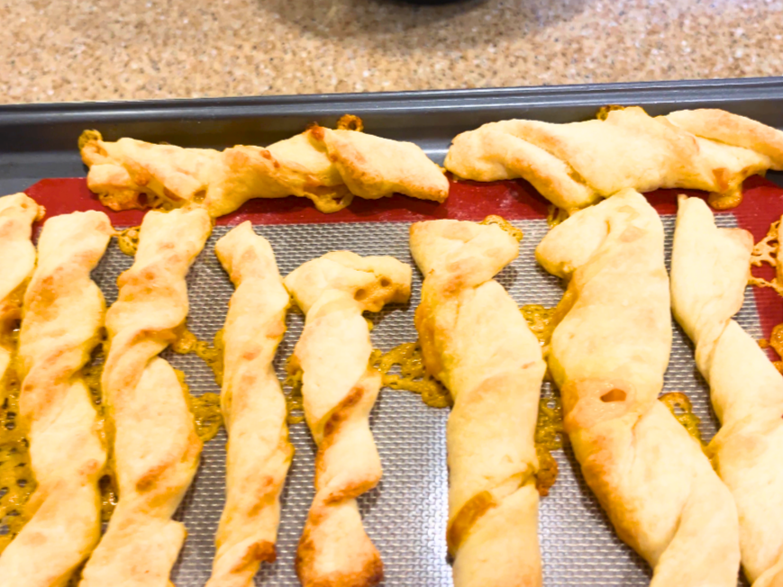 Baked cheese straws on a baking sheet.