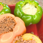 A casserole dish with stuffed peppers. They are full of ground meat and cheese.