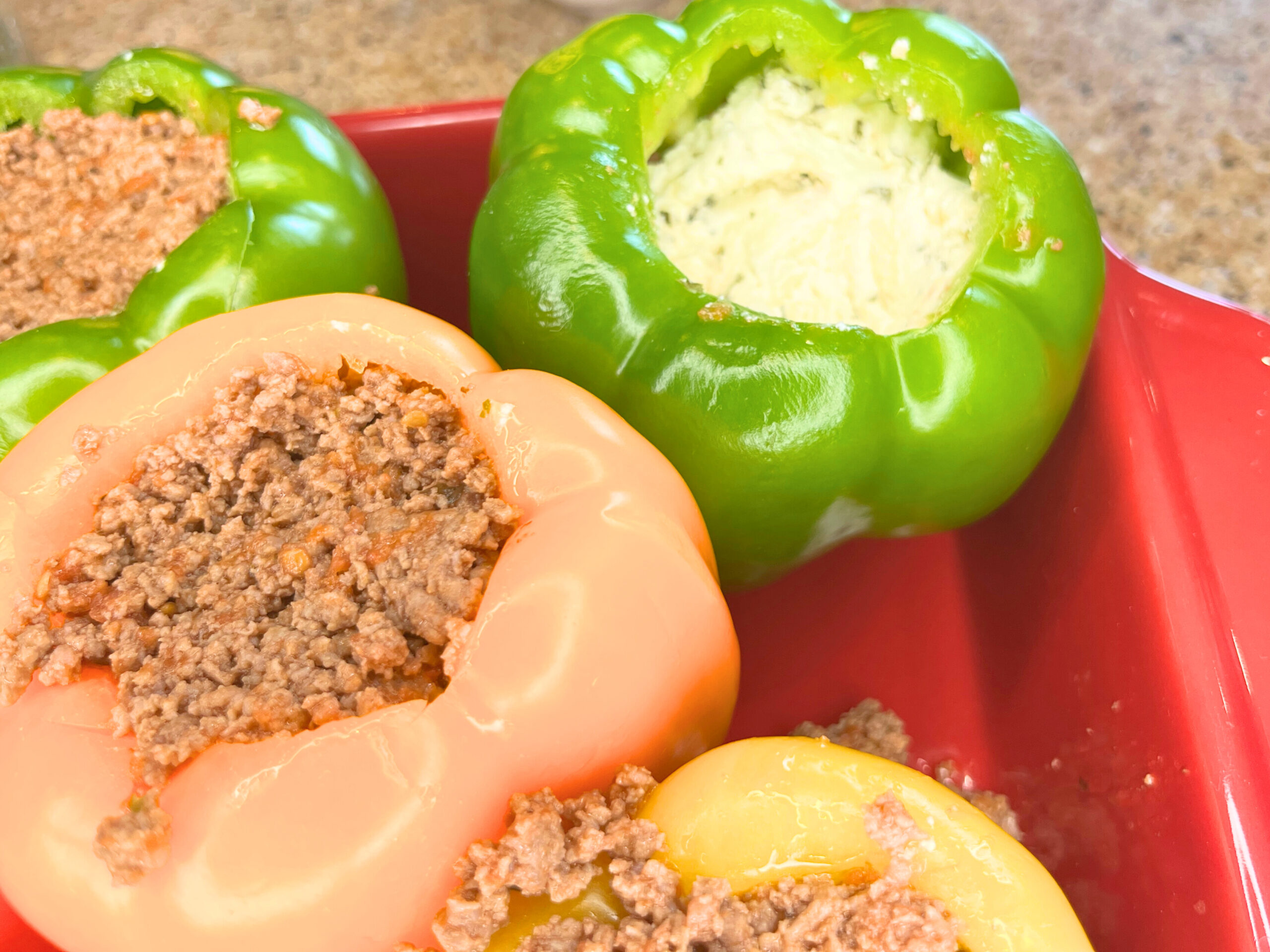 A casserole dish with stuffed peppers. They are full of ground meat and cheese.