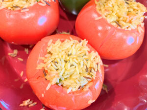 Some stuffed tomatoes on a red dish.