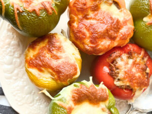 A plate of stuffed peppers with melted cheese on top.