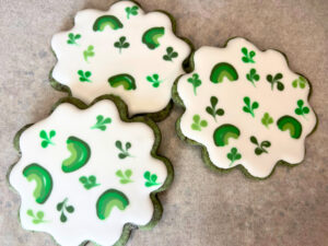 A group of three St. Patrick's day sugar cookies decorated with royal icing.