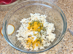 A bowl with rice, spices, and parsley.