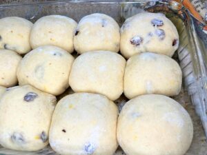 Risen buns in a casserole dish.