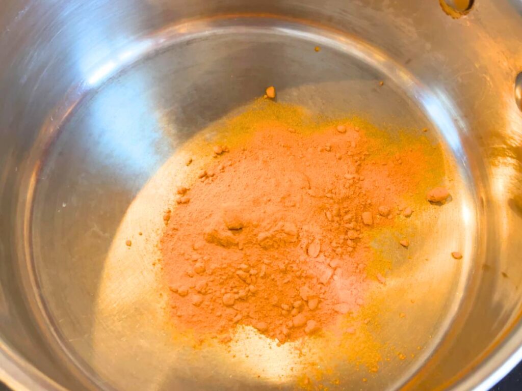A pot with yellow powder in the bottom.