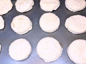 Circles of dough cutouts on a baking sheet.