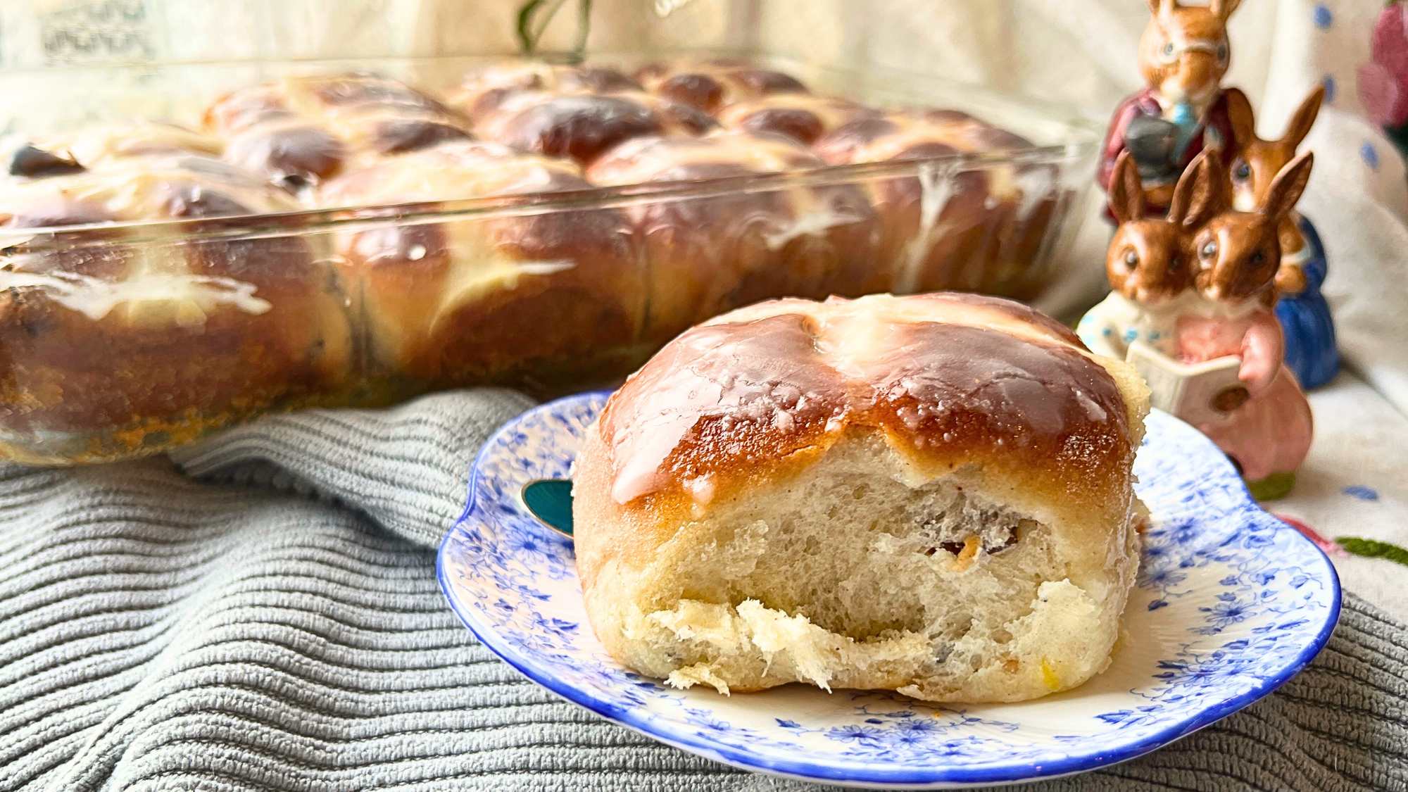 A side view of a hot cross bun. There are more in the background.