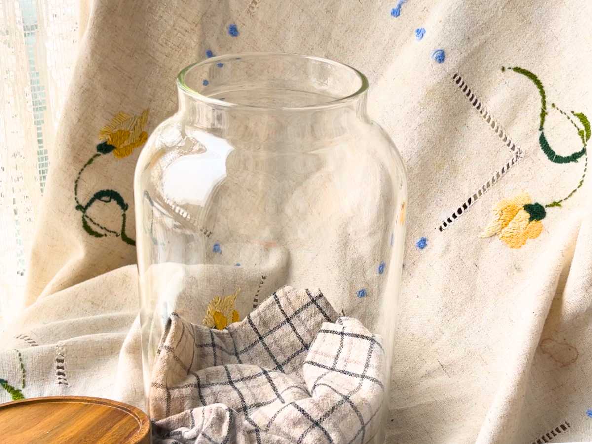 A large glass jar with a kitchen towel inside.
