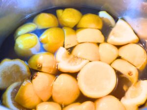 Lemon chunks in a large pot of water.