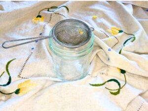 A small strainer over a glass canning jar