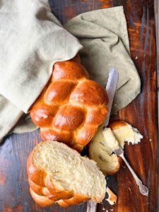 A braided bread loaf that has been cut to show the inside.