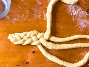 Four ropes of dough being braided.