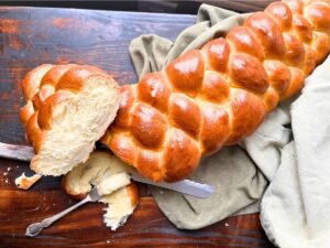 A braided bread loaf that is cut in half to show the inside.