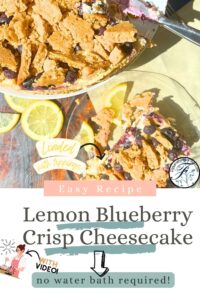 This is a pinterest pin for a lemon blueberry crisp cheesecake. In the photo there is a cheesecake on a cake stand it has cookie pieces and blueberries on top. There is a slice cut out of it. In front is a glass plate with a slice of the cake.