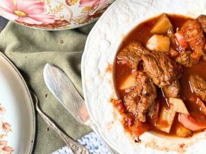 A close up look at a white bowl with beef and vegetables in it