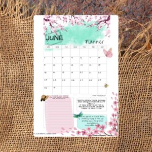 A burlap background. There is a calendar for June on top. It has a floral pink and teal design.