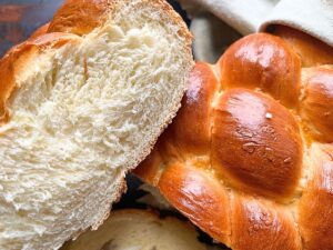 A braided bread loaf that has been cut to show the inside of the loaf.