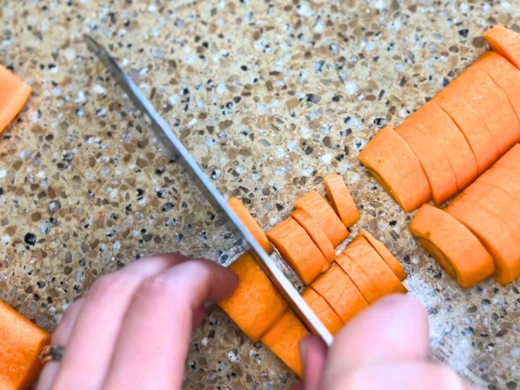 A woman cutting carrots.
