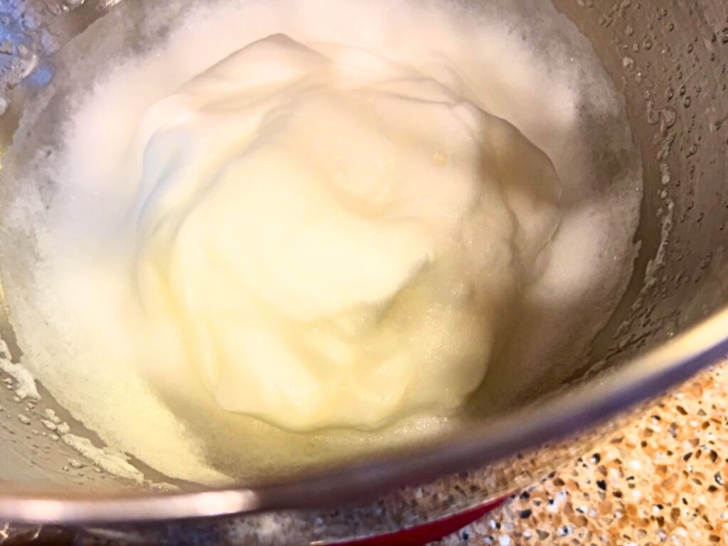 A metal bowl with whipped egg whites.