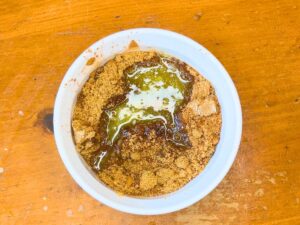 A small white bowl with brown sugar, cinnamon, and melted butter.