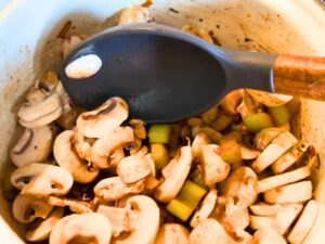 Woman frying mushrooms in a white pot