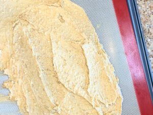 Batter smoothed out onto a lined baking sheet.