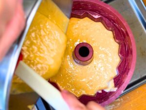 Woman pouring batter into a Bundt pan.