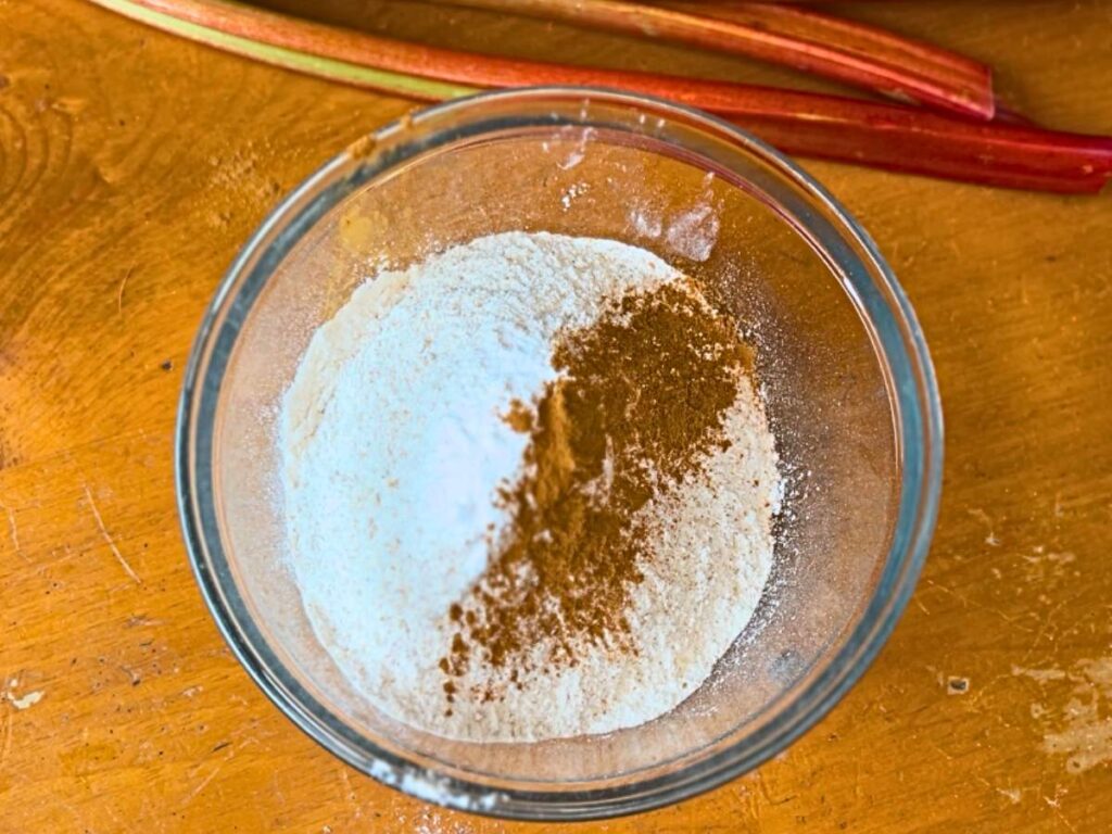 A glass bowl with flour, and cinnamon.