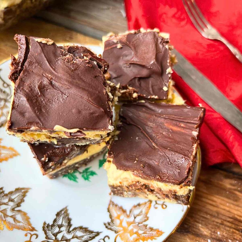 Three Nanaimo bars on a gold maple leaf plate.