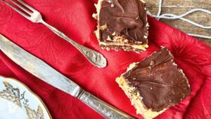 There are two Nanaimo bars on a red napkin.